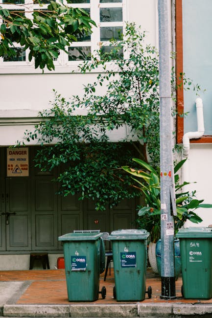 A narrow urban alleyway lined with a dense array of building ventilation systems, air conditioning units, and various pipes mounted on the exterior walls. The units are primarily white or metallic, wi